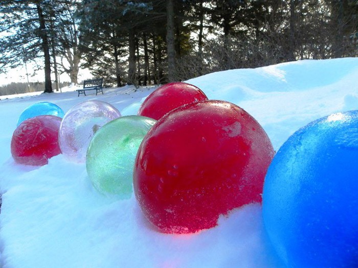 Наливаем в шарик окрашенную воду и оставляем замерзать. Разрываем оболочку шарика и являем миру яркую ледовую игрушку большого размера